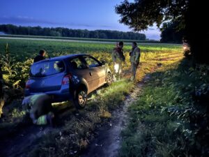 Brandweer helpt auto uit weiland