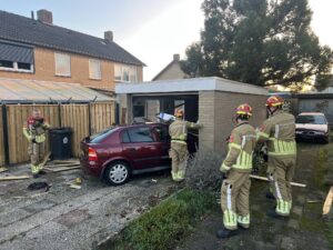 Automobiliste rijdt door hekwerk garage in